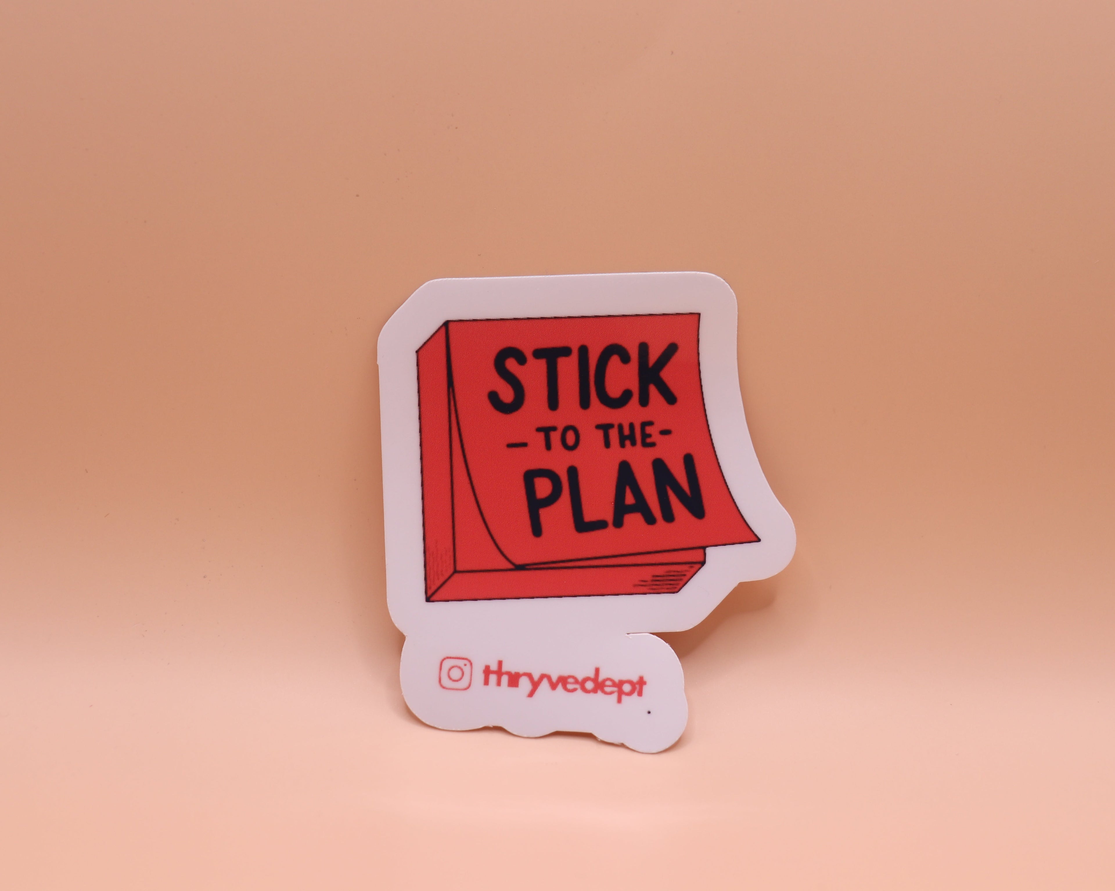 Sticker with 'Stick to the Plan' text on a beige background